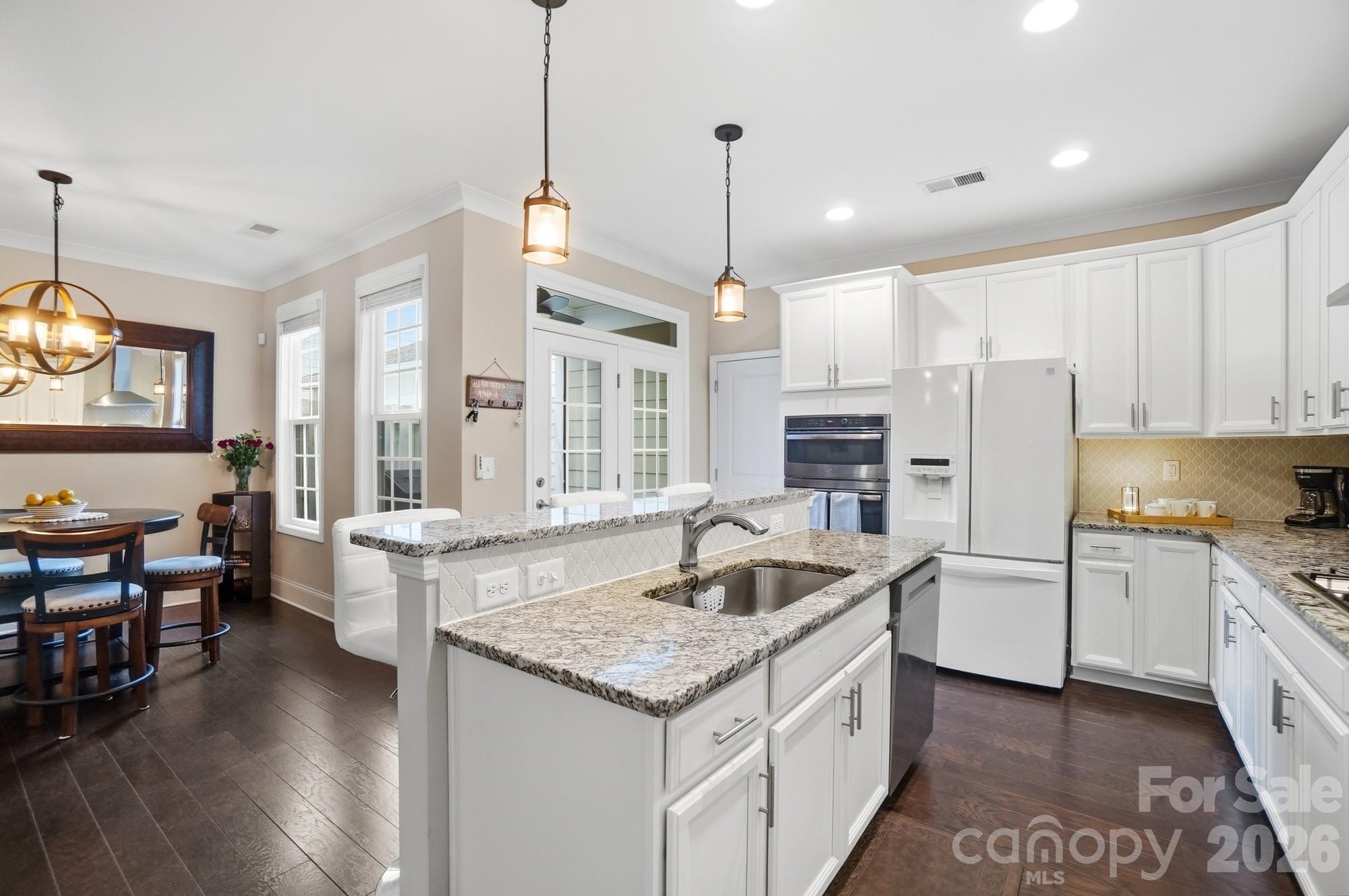 6270 Hove Road Mint Hill, NC 28227 - Photo 14 of 46 a kitchen with stainless steel appliances granite countertop a stove oven and a refrigerator a oven with wooden floors