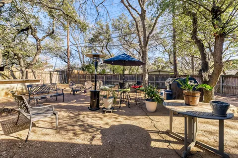 a view of a patio with chairs and potted plants