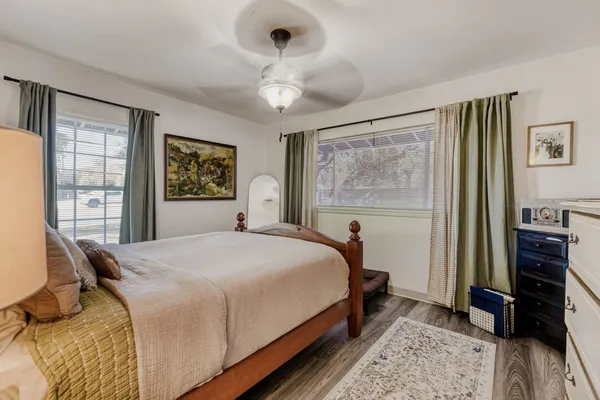 a bedroom with a bed and a dresser next to a window