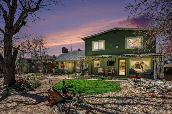 a view of a house with a yard potted plants and large tree