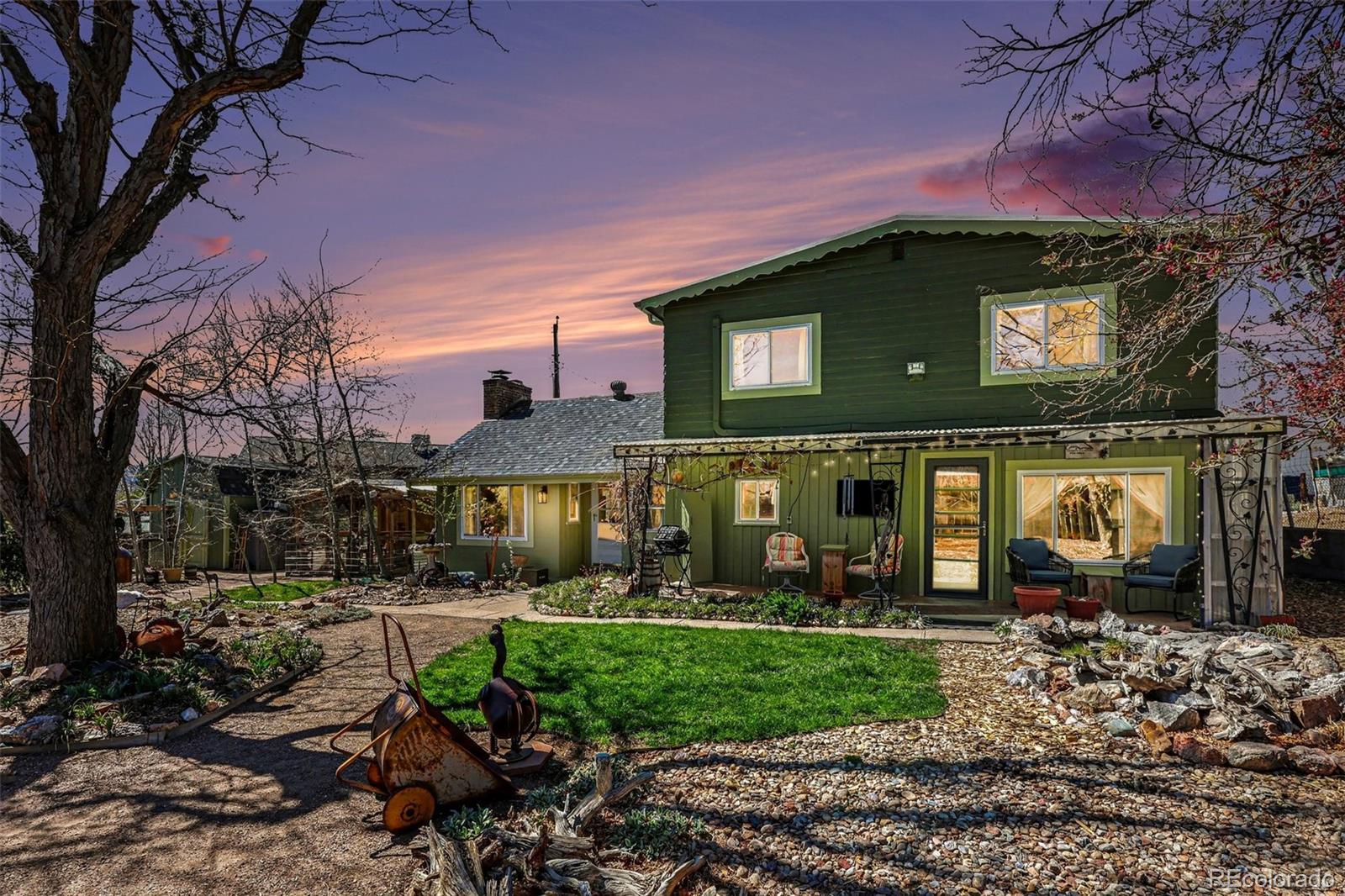 a view of a house with a yard potted plants and large tree