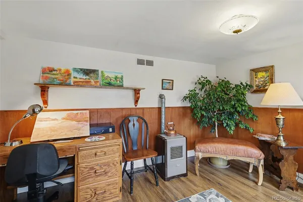 a bedroom with a bed and a potted plant on the dresser