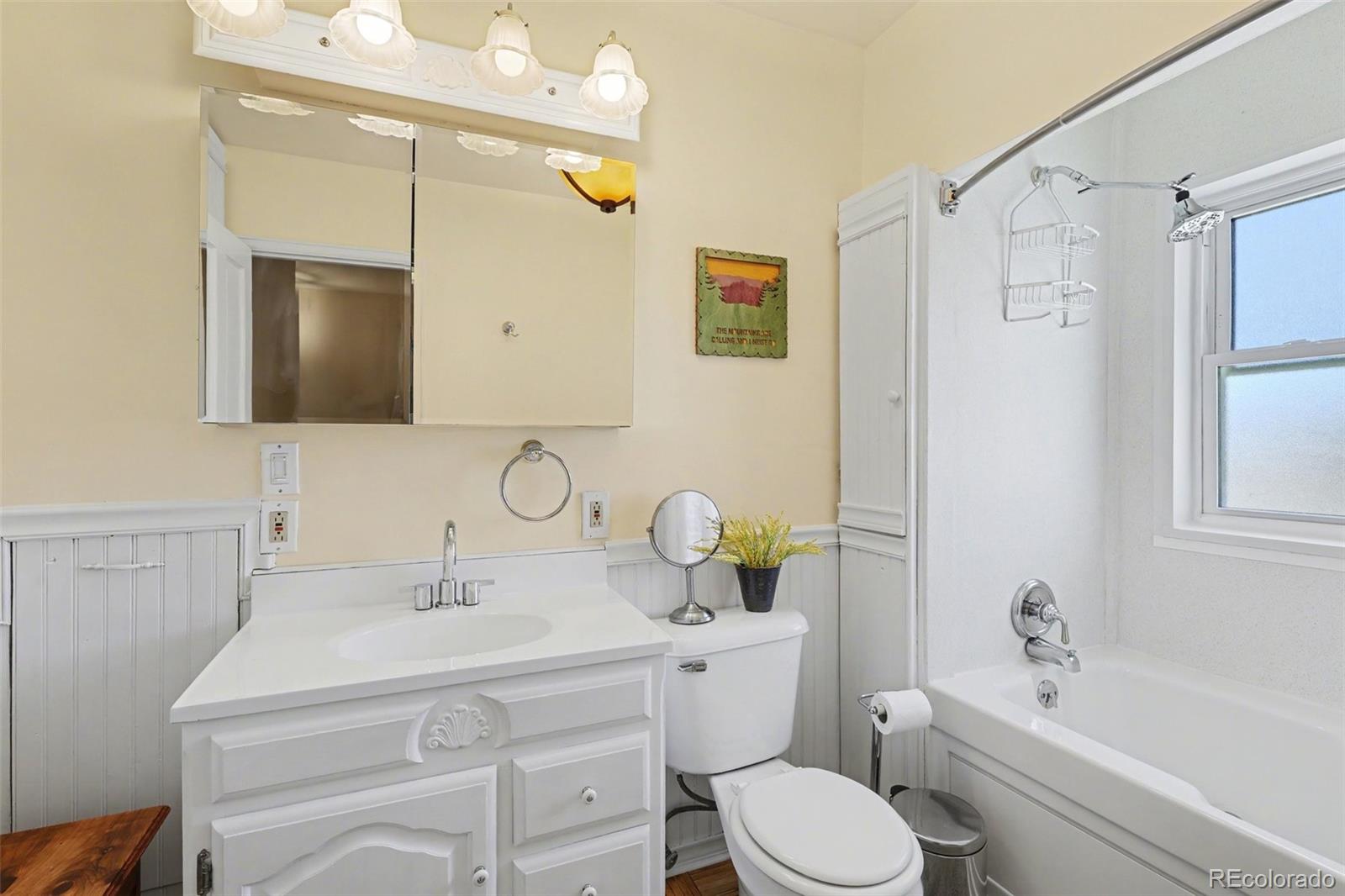 9795 Morrison Road Lakewood, CO 80227 - Photo 18 of 27 a bathroom with a sink toilet a mirror and shower