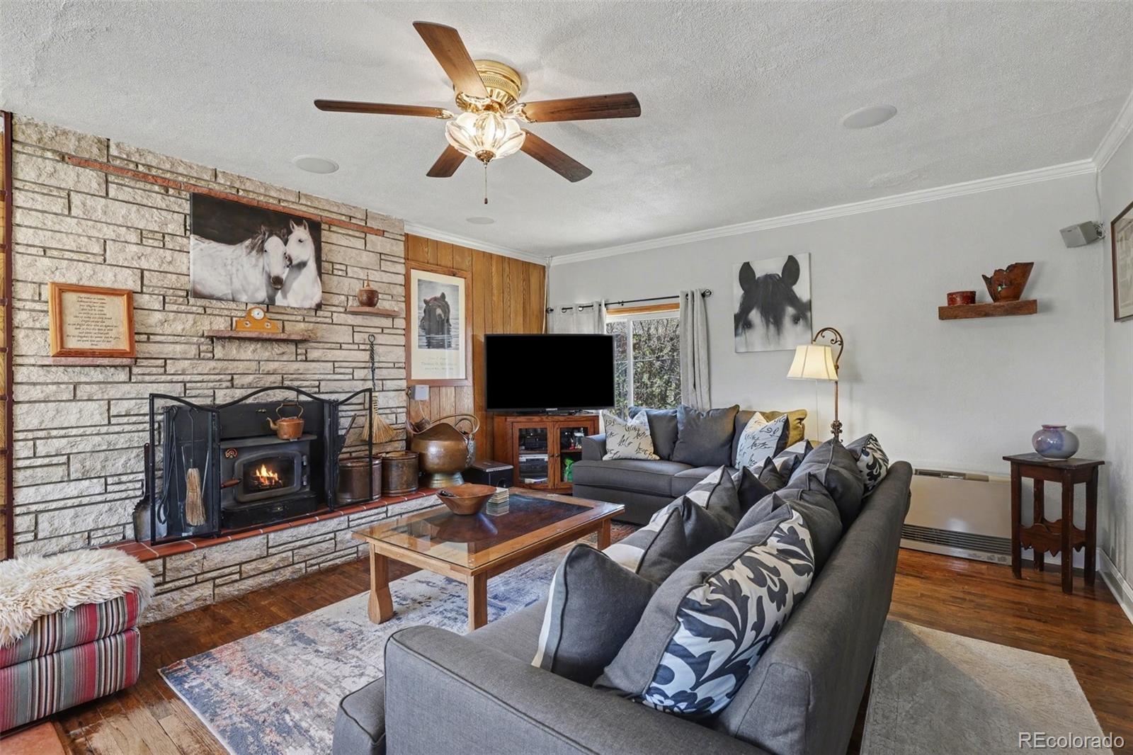 9795 Morrison Road Lakewood, CO 80227 - Photo 5 of 27 a living room with furniture a flat screen tv and a fireplace