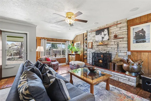 a living room with furniture a fireplace and a large window