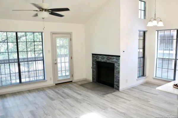 wooden floor fireplace and windows in an empty room