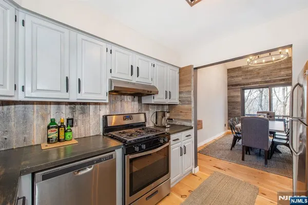a kitchen with stainless steel appliances granite countertop a stove sink and cabinets