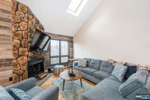 a living room with furniture a fireplace and a large window