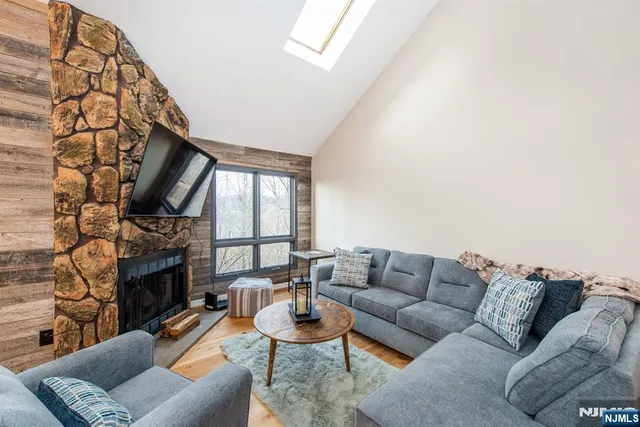 a living room with furniture a fireplace and a large window