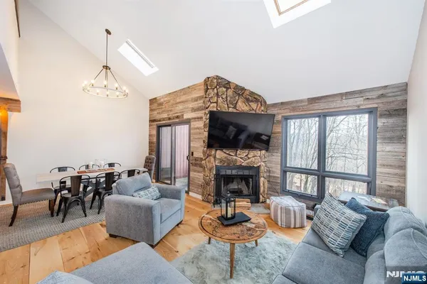 a living room with furniture a fireplace and a chandelier