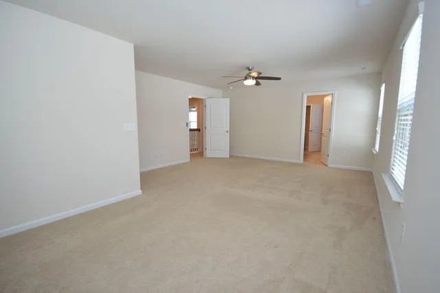 an empty room with windows and fan view