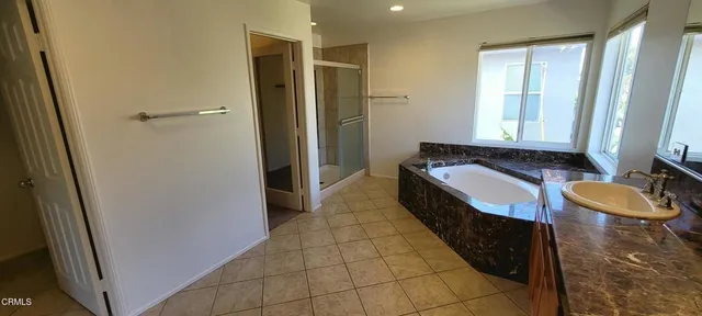 a spacious bathroom with a granite countertop tub sink and mirror