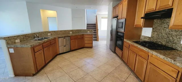 a kitchen with stainless steel appliances granite countertop a stove and a refrigerator