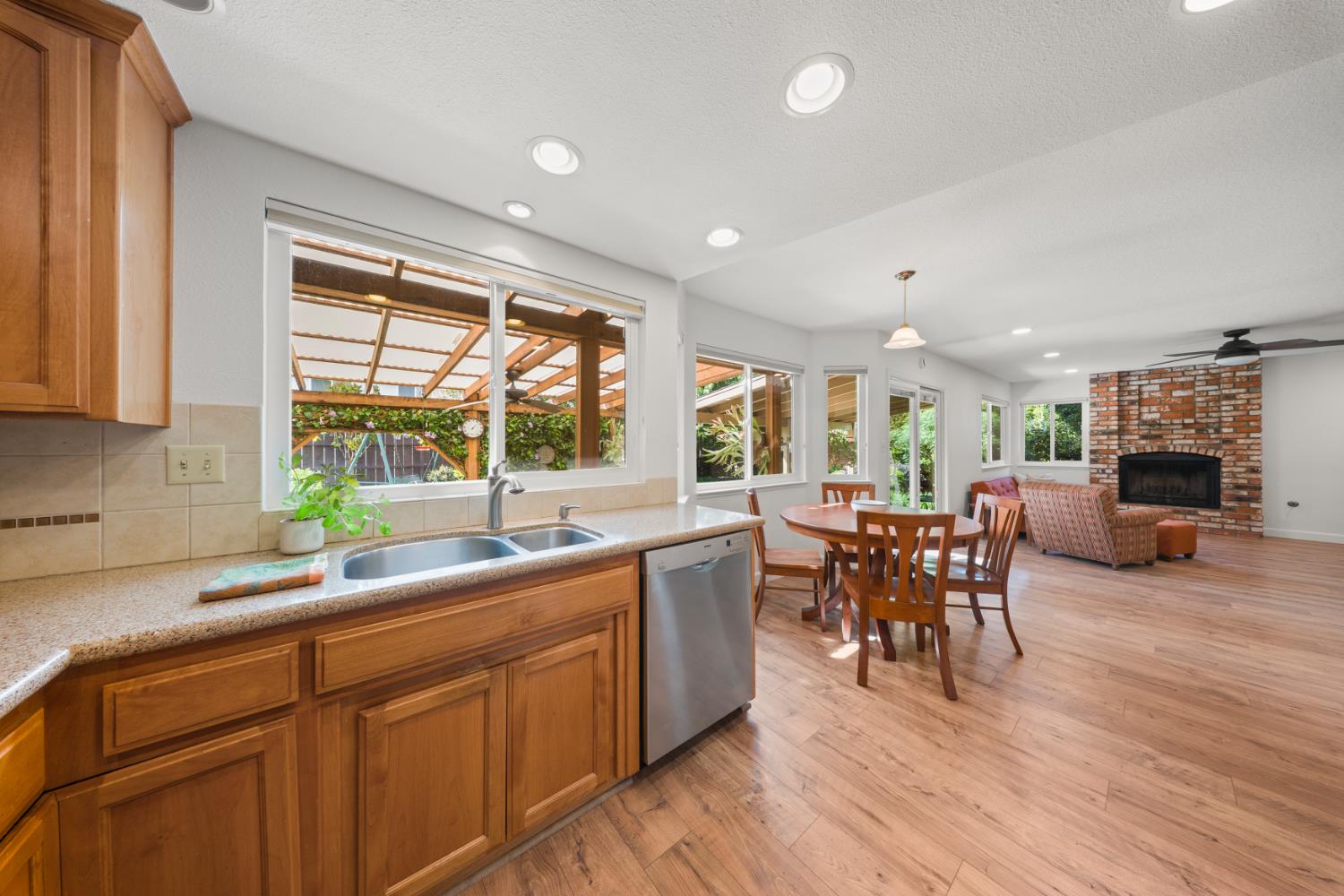 1325 Forest Drive Turlock, CA 95380 - Photo 20 of 28 a kitchen with a sink dining table wooden floor and a large window
