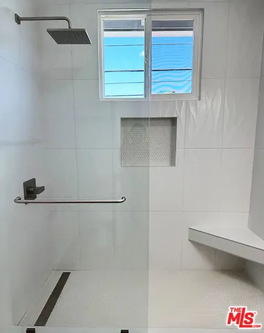 a view of an empty room with wooden floor and cabinet