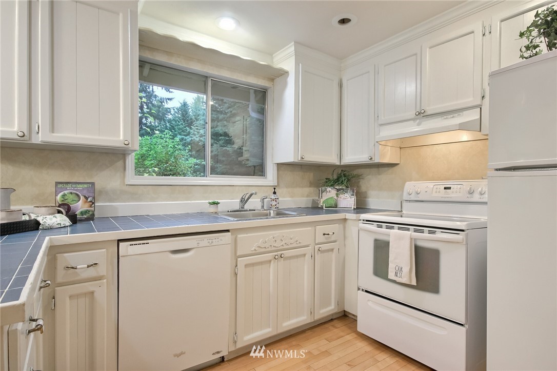 4321 196th Street Southeast Bothell, WA 98012 - Photo 17 of 40 a kitchen with white cabinets and white appliances