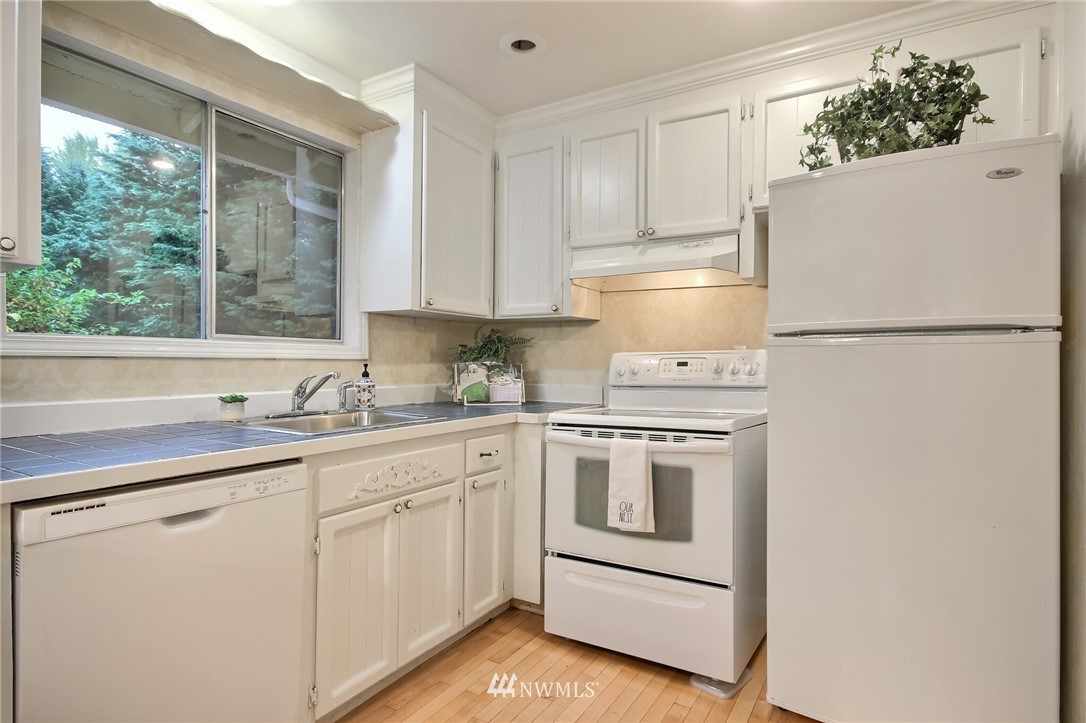 4321 196th Street Southeast Bothell, WA 98012 - Photo 18 of 40 a kitchen with white cabinets and white appliances