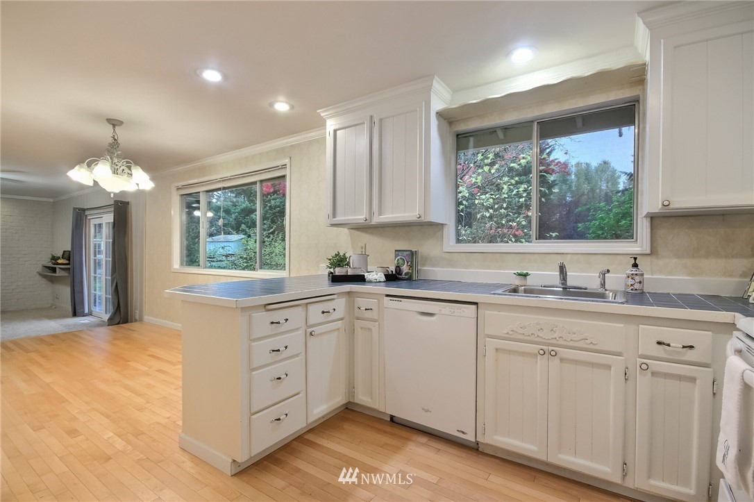 4321 196th Street Southeast Bothell, WA 98012 - Photo 19 of 40 a kitchen with white cabinets and window