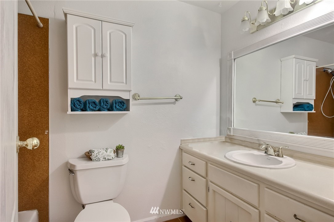 4321 196th Street Southeast Bothell, WA 98012 - Photo 33 of 40 a bathroom with a toilet sink a mirror and vanity