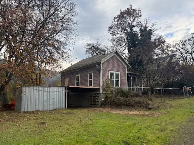 a front view of a house with a garden and trees
