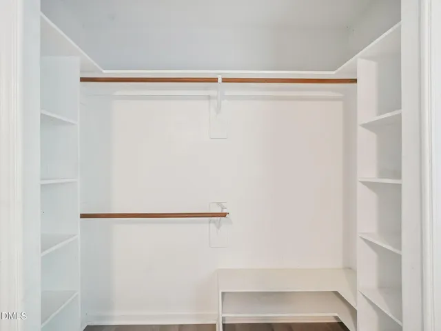 a view of walk in closet with empty racks