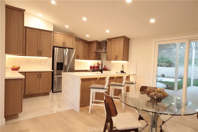 a kitchen with a dining table chairs refrigerator and cabinets