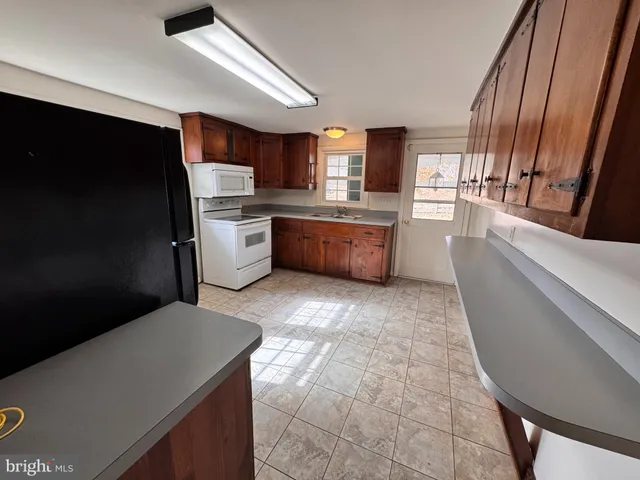 a kitchen with a sink a stove top oven and cabinetry