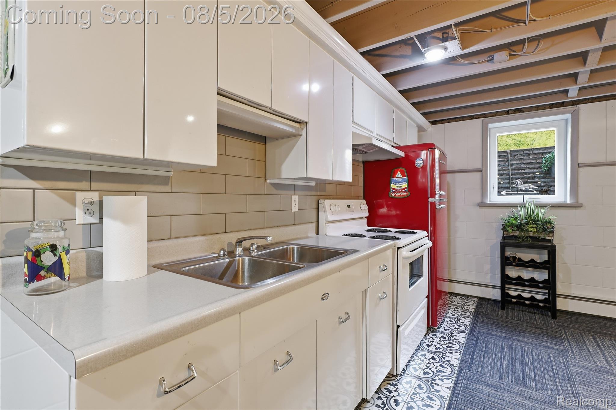 6478 West Stanley Road Mount Morris, MI 48458 - Photo 55 of 80 Compact kitchen featuring white cabinetry, a double basin stainless steel sink, a tile backsplash, and a retro-style red refrigerator
