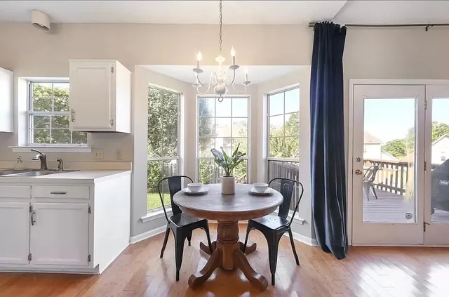 a dining room with furniture a chandelier and wooden floor