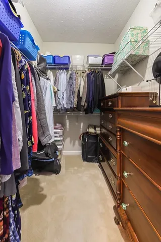 a view of walk in closet with clothes and shoes