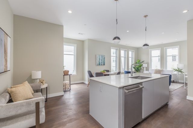 a view of a kitchen counter top space with granite countertop a sink and living room view