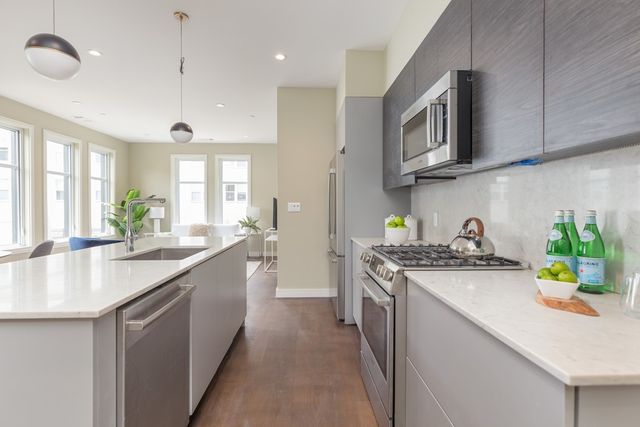 a kitchen with stainless steel appliances granite countertop a sink a stove top oven a counter space and cabinets