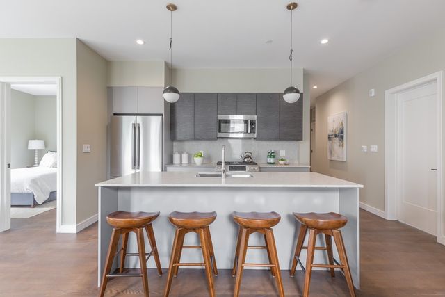 a large kitchen with a table chairs refrigerator and wooden floor