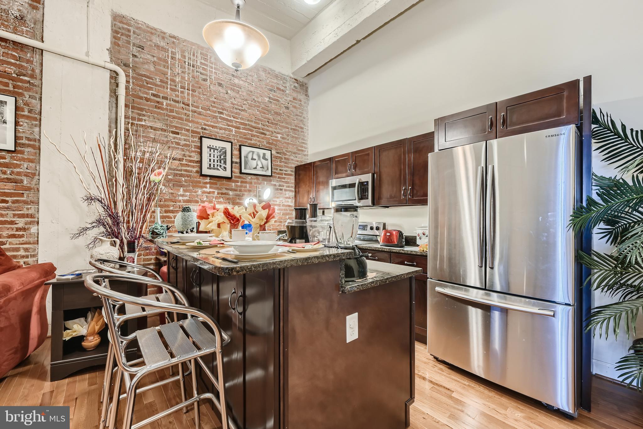 311 West Baltimore Street, Unit 104 Baltimore, MD 21201 - Photo 4 of 28 a kitchen with stainless steel appliances a stove a refrigerator and a refrigerator