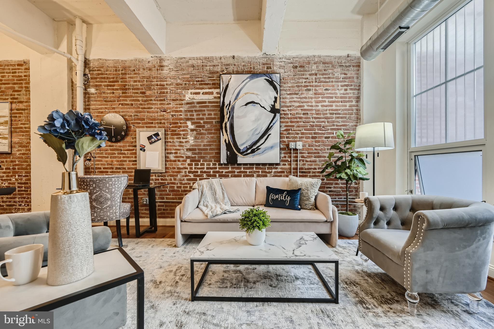 311 West Baltimore Street, Unit 104 Baltimore, MD 21201 - Photo 6 of 28 a living room with furniture a rug and a floor to ceiling window