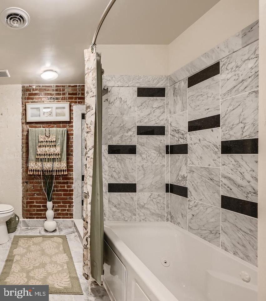 311 West Baltimore Street, Unit 104 Baltimore, MD 21201 - Photo 8 of 28 a bathroom with a bathtub and a shower