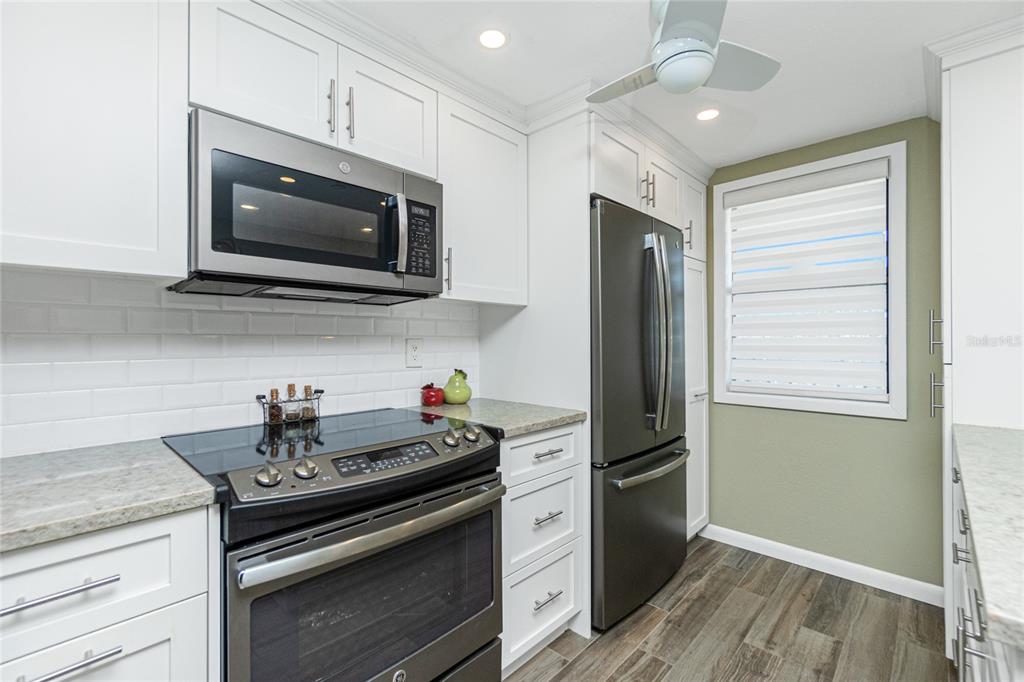 1591 Beach Road, Unit 403 Englewood, FL 34223 - Photo 21 of 61 a kitchen with stainless steel appliances granite countertop a stove microwave and refrigerator