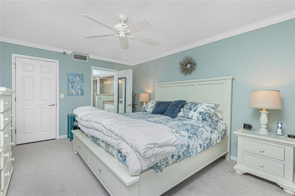 1591 Beach Road, Unit 403 Englewood, FL 34223 - Photo 25 of 61 a bedroom with a large bed and a chandelier