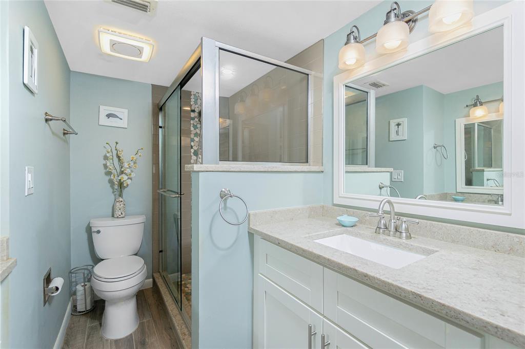 1591 Beach Road, Unit 403 Englewood, FL 34223 - Photo 26 of 61 a bathroom with a granite countertop sink a toilet and a mirror