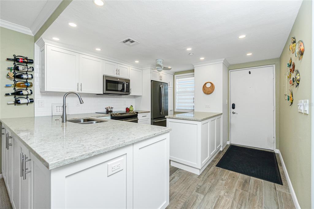 1591 Beach Road, Unit 403 Englewood, FL 34223 - Photo 3 of 61 a kitchen with stainless steel appliances granite countertop a sink stove and refrigerator