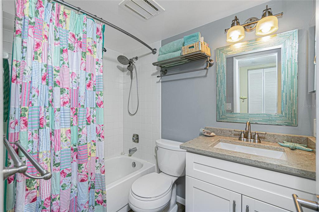 1591 Beach Road, Unit 403 Englewood, FL 34223 - Photo 32 of 61 a bathroom with a granite countertop sink mirror vanity and toilet