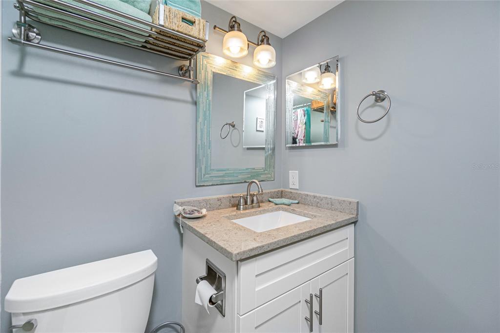 1591 Beach Road, Unit 403 Englewood, FL 34223 - Photo 33 of 61 a bathroom with a sink a toilet and a mirror