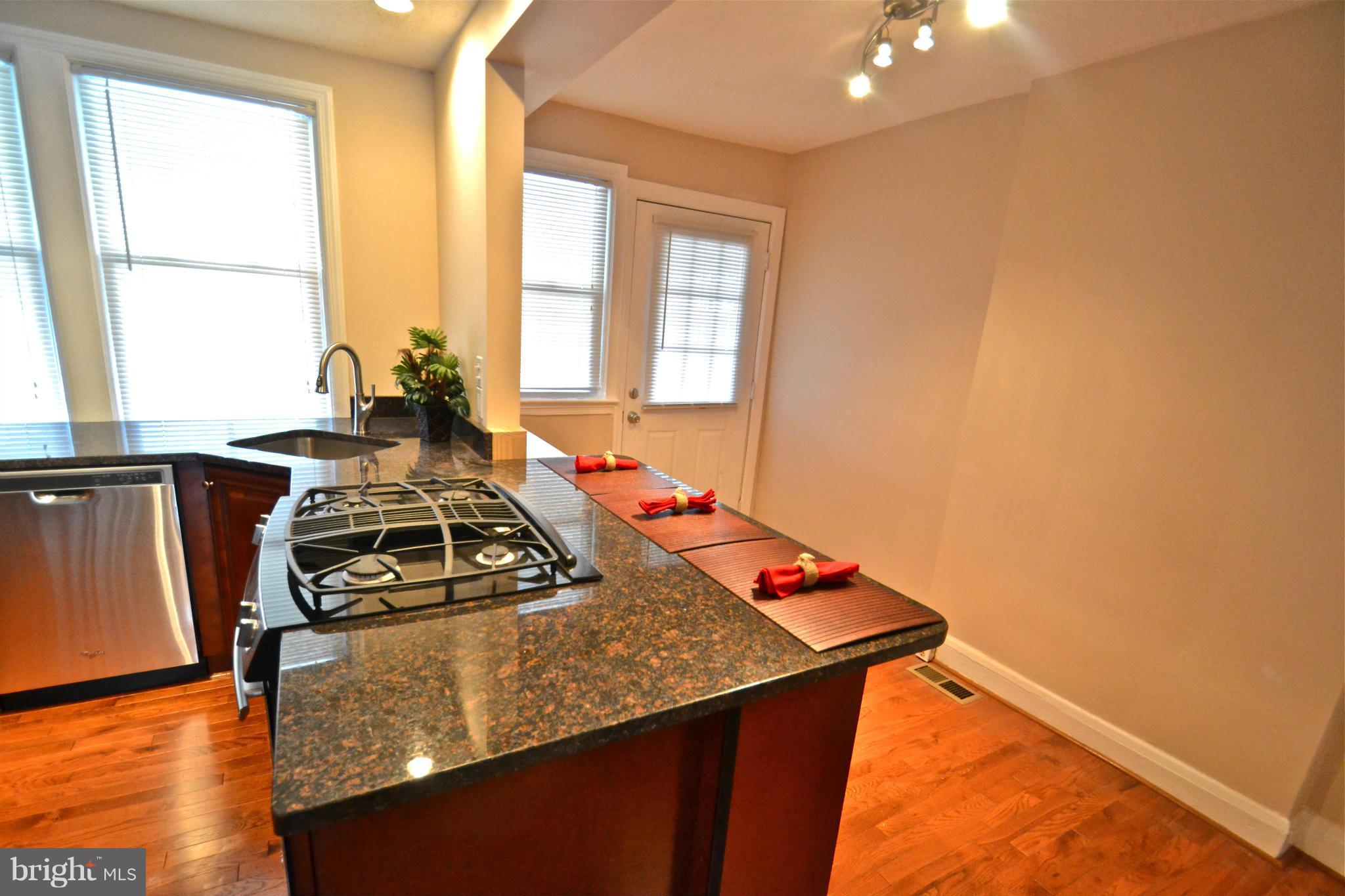 236 West Edgevale Road Baltimore, MD 21225 - Photo 11 of 30 a kitchen with a stove a sink and a window
