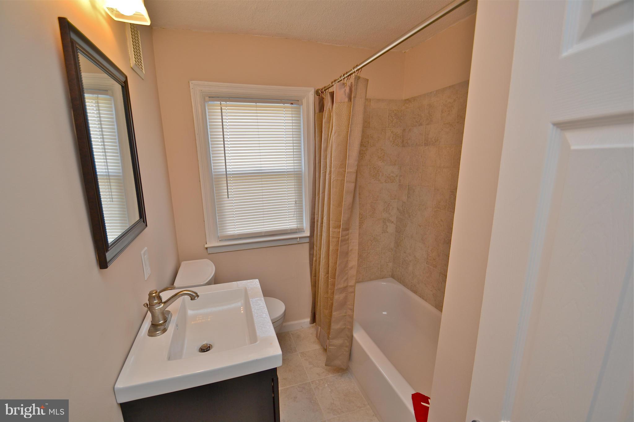 236 West Edgevale Road Baltimore, MD 21225 - Photo 20 of 30 a bathroom with a sink a window and shower