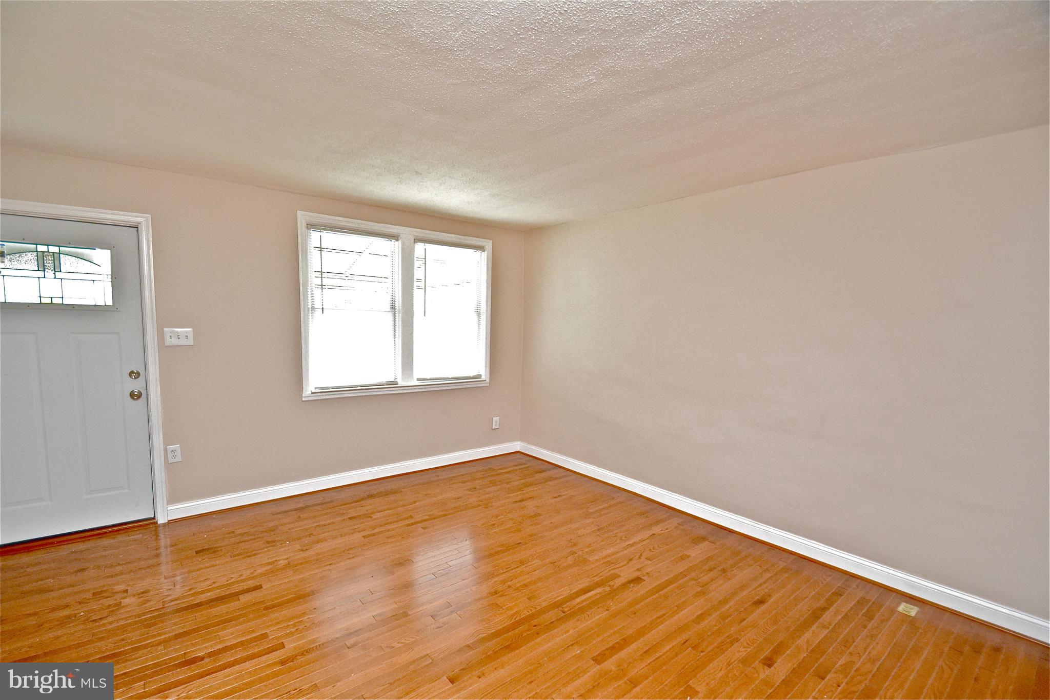 236 West Edgevale Road Baltimore, MD 21225 - Photo 3 of 30 an empty room with wooden floor and windows