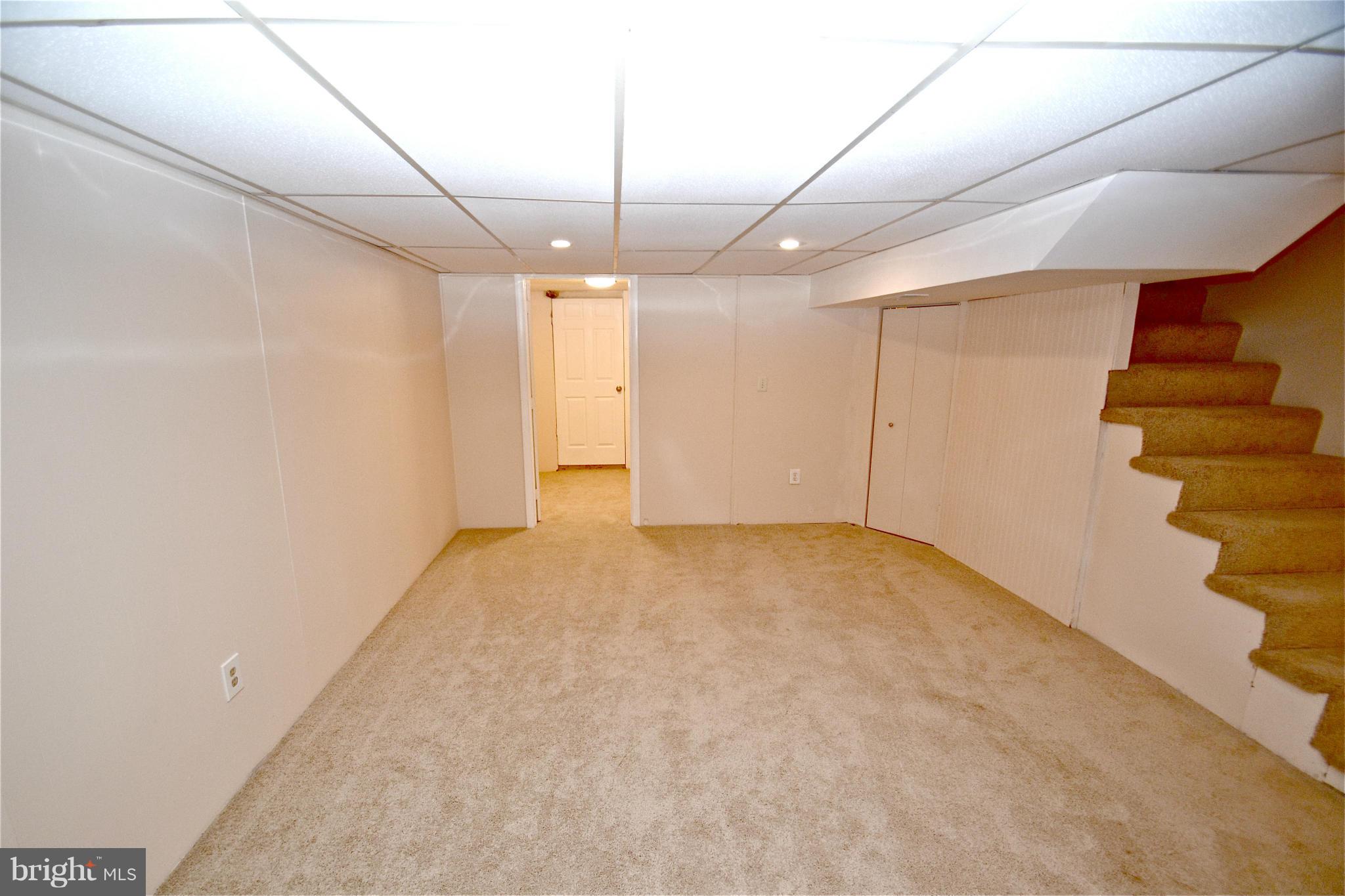 236 West Edgevale Road Baltimore, MD 21225 - Photo 23 of 30 an empty room with a ceiling fan and stairs