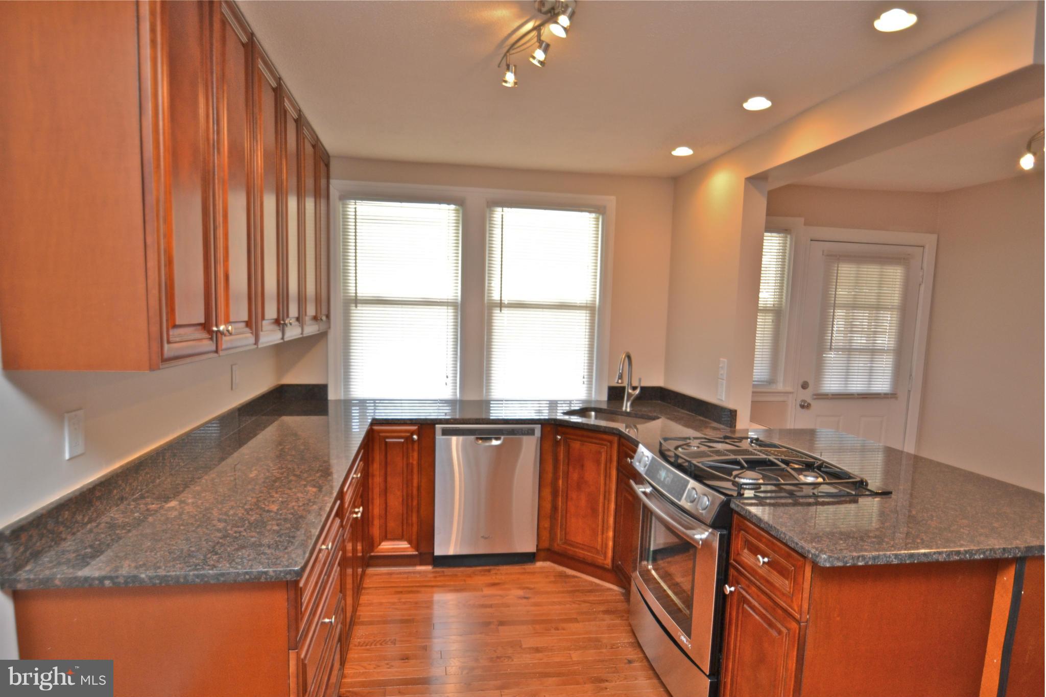 236 West Edgevale Road Baltimore, MD 21225 - Photo 5 of 30 a kitchen with stainless steel appliances granite countertop a sink stove and cabinets