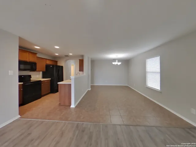 a view of kitchen with kitchen island white cabinets and refrigerator