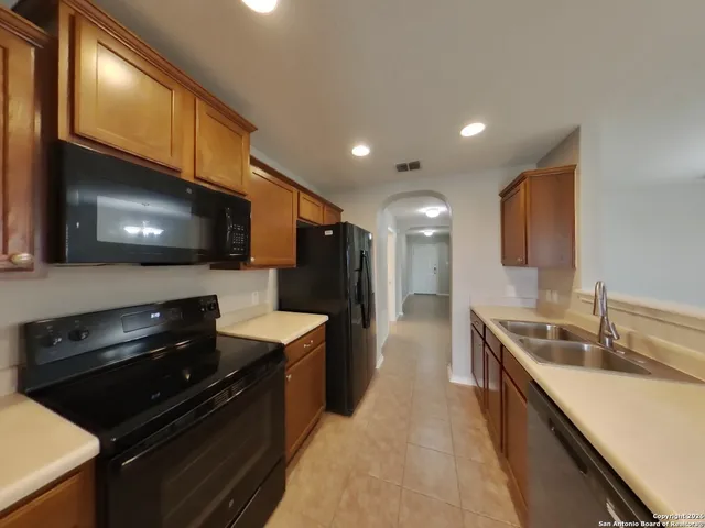 a kitchen with stainless steel appliances wooden cabinets a sink and a stove