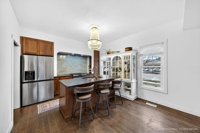 a kitchen with stainless steel appliances a dining table and chairs